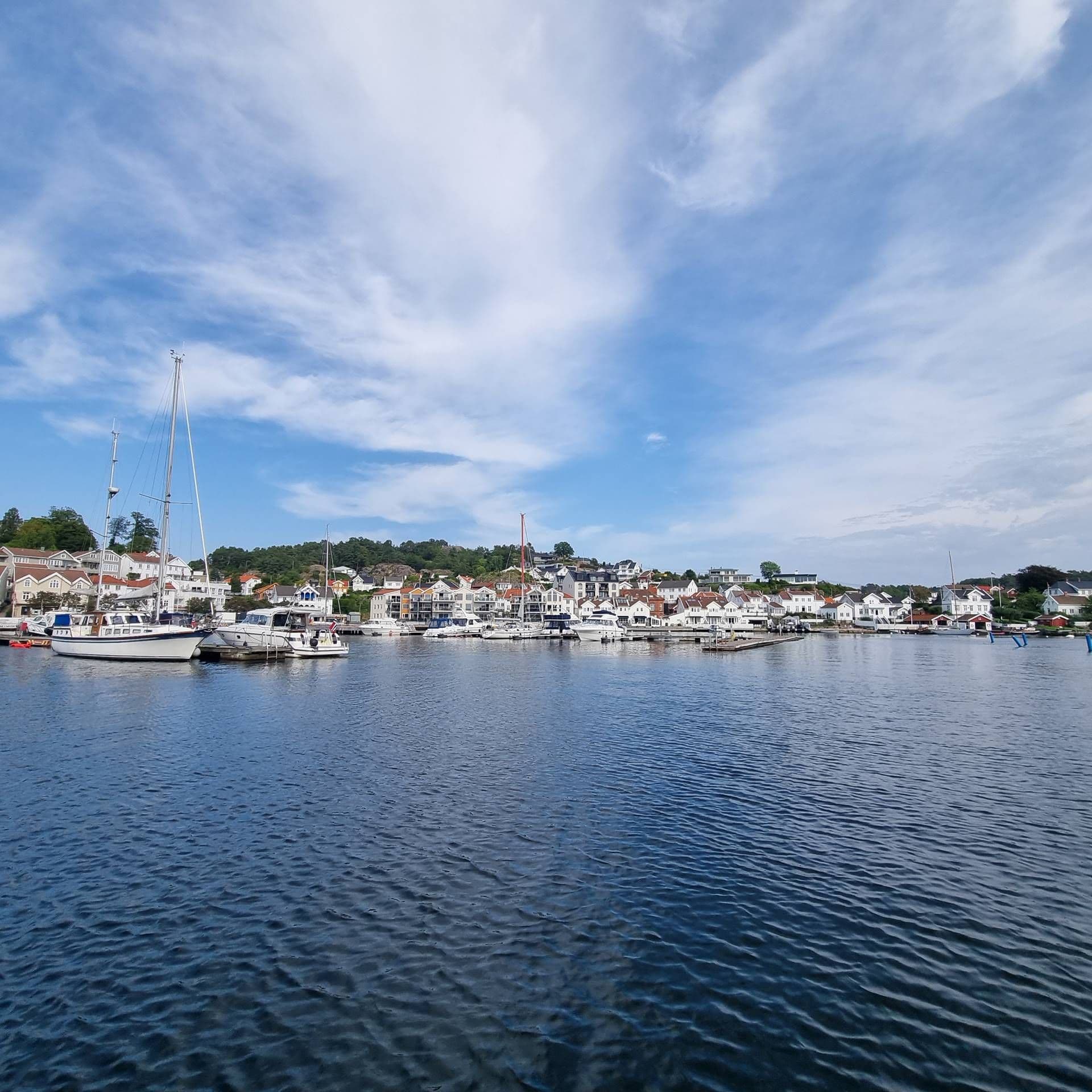 Foto av Grimstad havn med Biodden i bakgrunnen. 